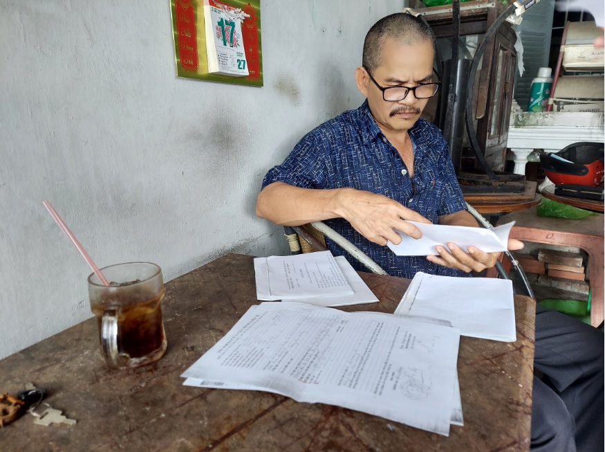 Ông Trần Văn Hùng xem hồ sơ anh trai mình – Trần Văn Vui, mòn mỏi chờ đợi tin vui